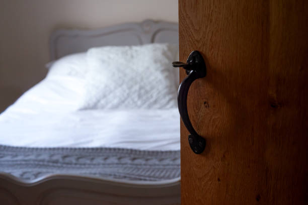 une chambre tranquille avec lit vintage et porte en bois rustique avec poignée antique - bed and breakfast photos et images de collection