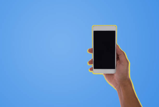 istock Man hand holding black smartphone colored background 1142270489
