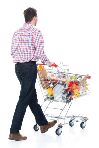 istock Handsome man pushing a shopping cart with food inside - walking 1142271467