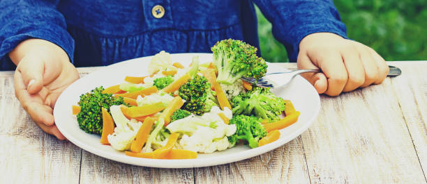 istock child eats vegetables. Summer photo. Selective focus 1142273916