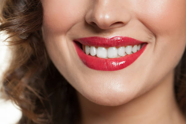 istock Female smiling lips with red lipstick makeup 1142275240