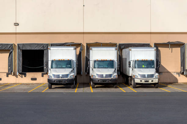 istock Small compact rigs semi trucks with box trailers standing in row at warehouse docks for loading cargo.jpg 1142275815