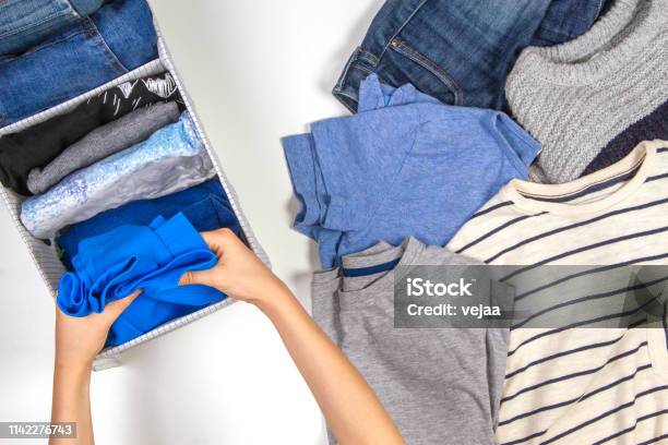 Vertical Storage Of Clothing Tidying Up Room Cleaning Concept Hands Tidying Up And Sorting Kids Clothes In Basket Stock Photo - Download Image Now
