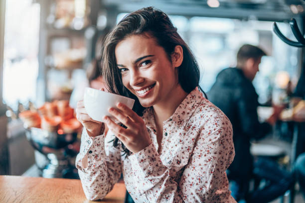 istock Happy young woman drinking coffee 1142277042