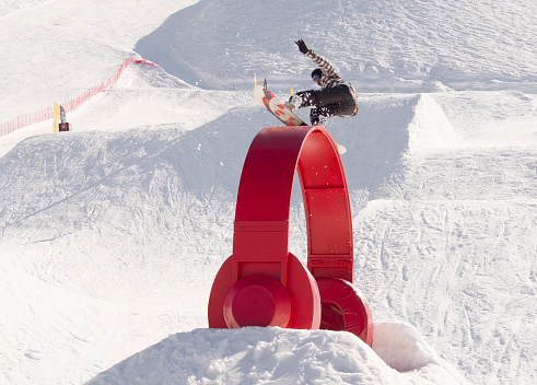 Krasnaya polyana, Sochi, Russia - April 7, 2019: Young man snowboarder sliding and jibbing in snowpark of Rosa Khutor