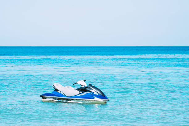 niebieski skuter hydrocycle w wodzie w pobliżu plaży. brak osób - wake jet boat water water sport zdjęcia i obrazy z banku zdjęć
