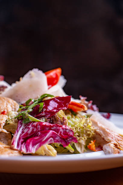 istock Cesar Salad in a salad bowl at a restaurant black background 1142295512