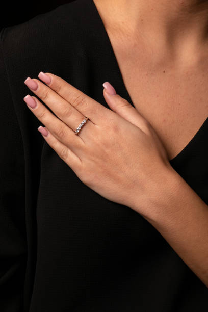 istock Womens silver diamonds ring with a fringe on finger, on a black background. 1142297967