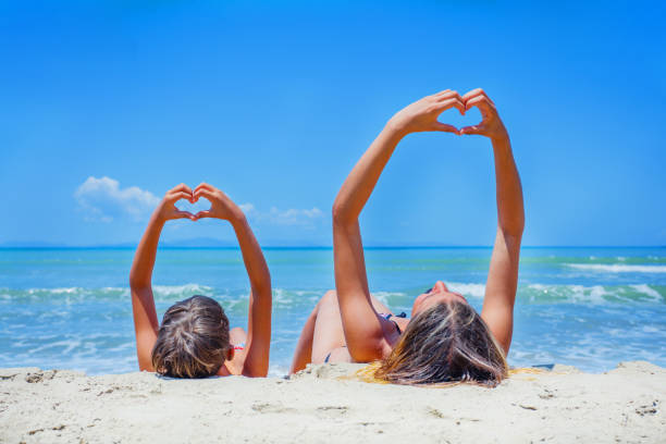 Adorable boy and girl playing on the beach on summer holidays. Children in nature with beautiful sea, sand and blue sky.