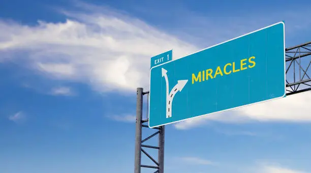 Large green - blue highway sign with text message about miracles