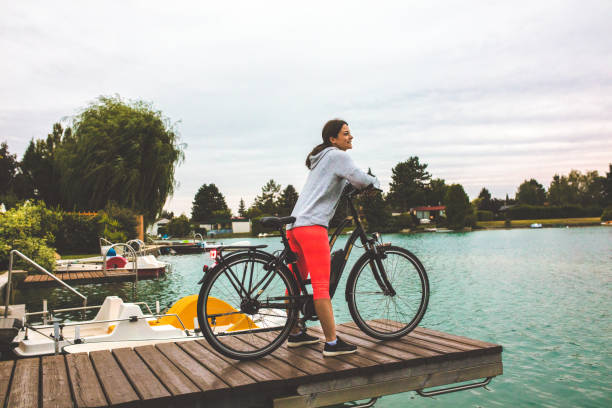 Woman with electric bicycle by lake