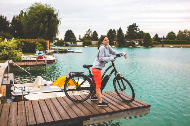 Woman with electric bicycle by lake
