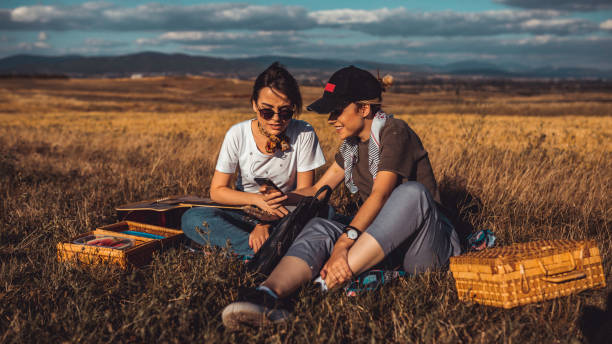 istock Twin sisters using having a picnic and using smart phone 1142311485
