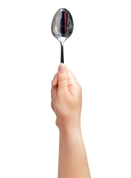 Woman hand holding up a spoon isolated on a white background