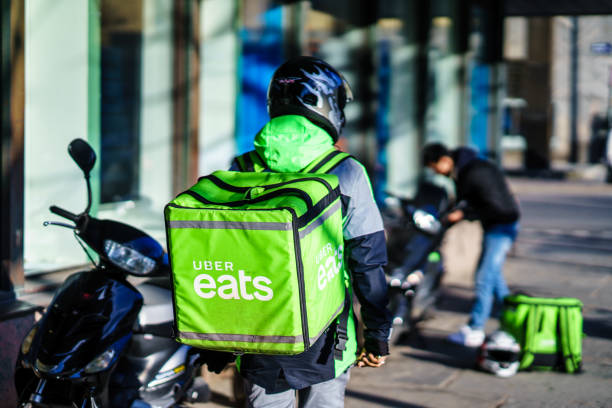 Uber eats delivery person carrying food to people who order by online app Gothenburg, Sweden - April 11, 2019: Uber eats delivery person carrying food to people who order by online app västra götaland county stock pictures, royalty-free photos & images