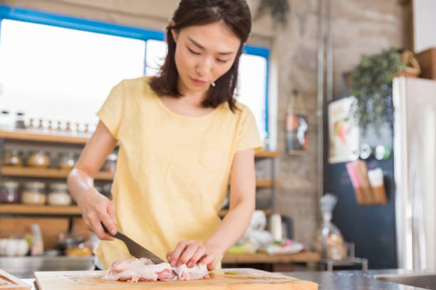 woman cooks in a kitchen, - white meat flash imagens e fotografias de stock