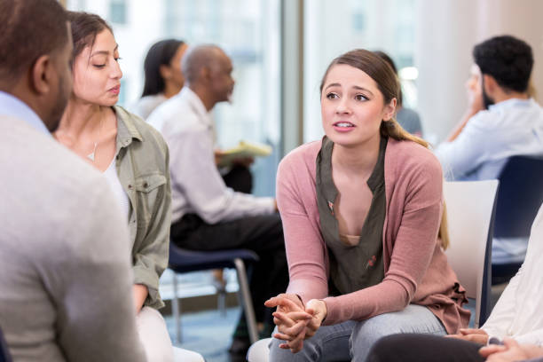 istock Concerned young woman shares with support group 1142334496