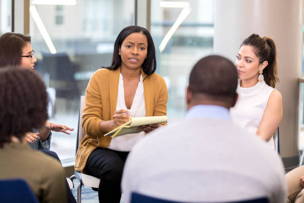 istock Counselor speaks to client during group therapy 1142334517