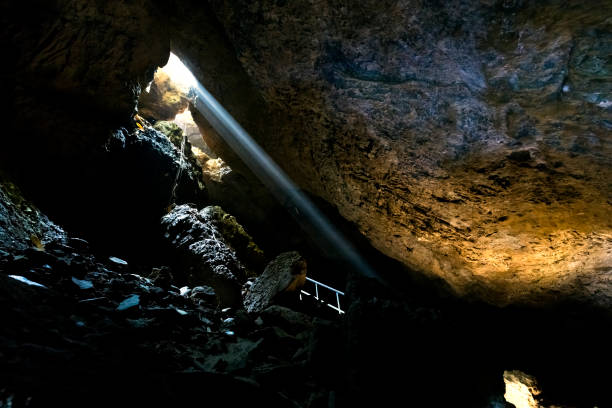 istock Bat Cave. sun light coming entrance 1142337021