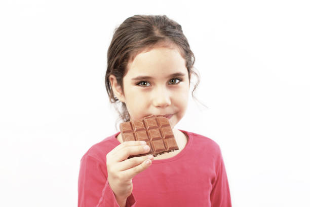 istock Happy kid girl eating  chocolate 1142349624