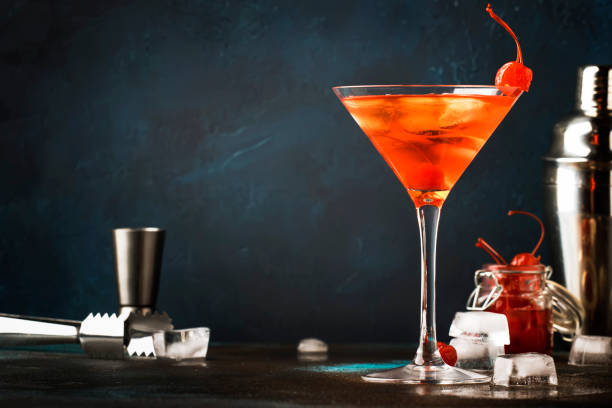 istock Classic alcoholic cocktail Manhattan with bourbon, red vemuth, bitter, ice and cocktail cherry in glass, gray bar counter background, place for text, selective focus 1142351245