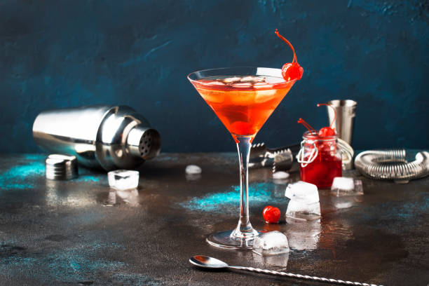 istock Classic alcoholic cocktail Manhattan with bourbon, red vemuth, bitter, ice and cocktail cherry in glass, gray bar counter background, place for text, selective focus 1142351259
