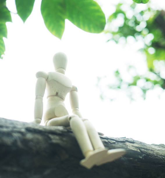istock Wood Mannequin Sitting on the tree 1142359051
