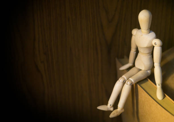 wooden man puppet sitting on white background