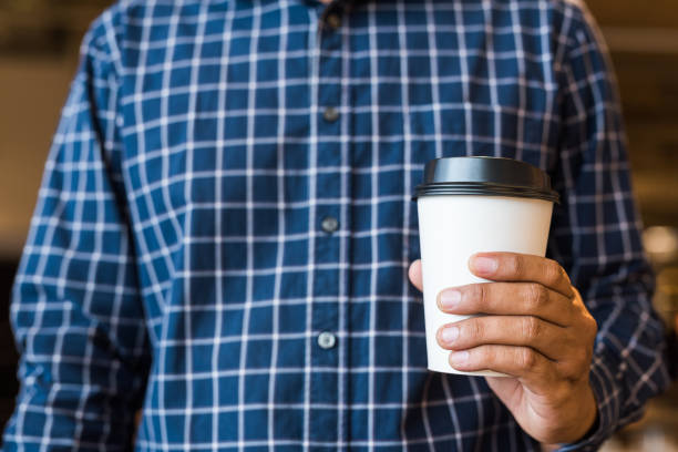 istock close up hand man holding coffee paper cup 1142359985