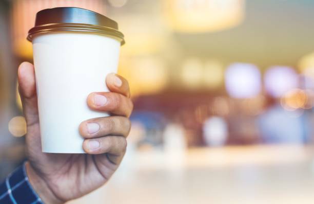 istock close up hand man holding coffee paper cup 1142360003