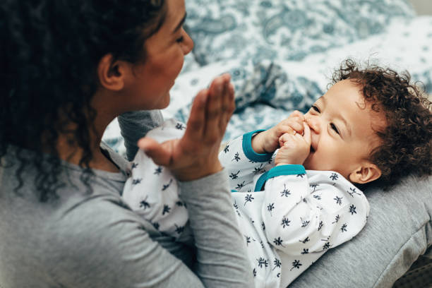 istock Happy baby boy lying on mother legs while she playing with him 1142361429