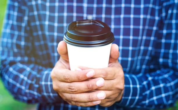 istock Close up male hand holding coffee paper cup. 1142361496