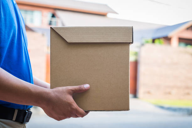 istock Blue Delivery man holding parcel cardboard box. 1142361515