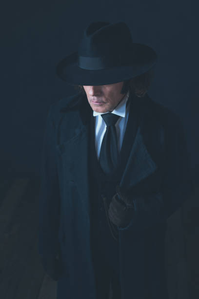 istock Mysterious victorian man in black coat and hat. 1142361872