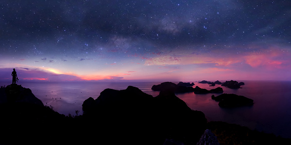 Man standing on the mountain with panorama view and million stars galaxy  , purple sky sunset at Ang thong archipelago island,Thailand