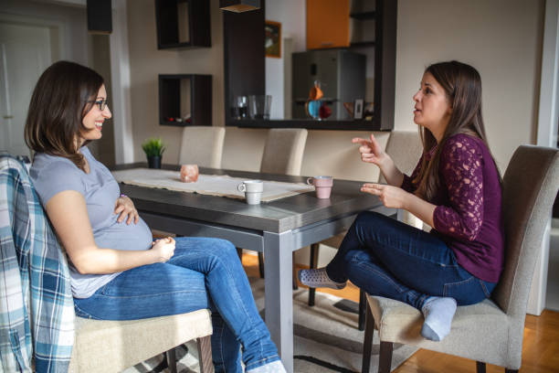 Deaf women exchanging experiences during coffee break with the aid of sign language