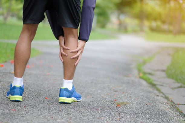 istock Low Section Of Man Touching Calf While Standing On Footpath 1142368643