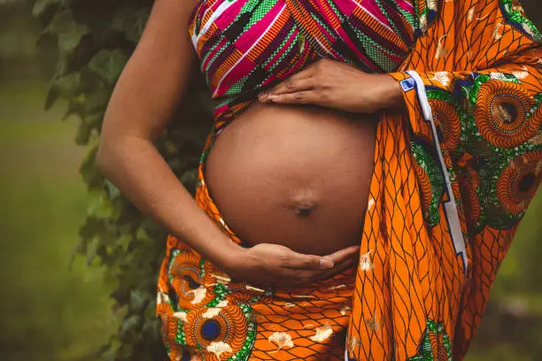 Look at my beautiful belly. Pregnant woman in the park. Close up.