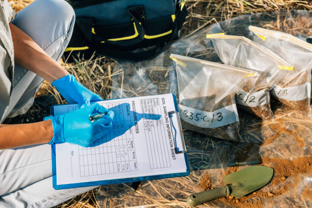 istock Low Section Of Agronomist Writing In Paper While Crouching On Field 1142369237