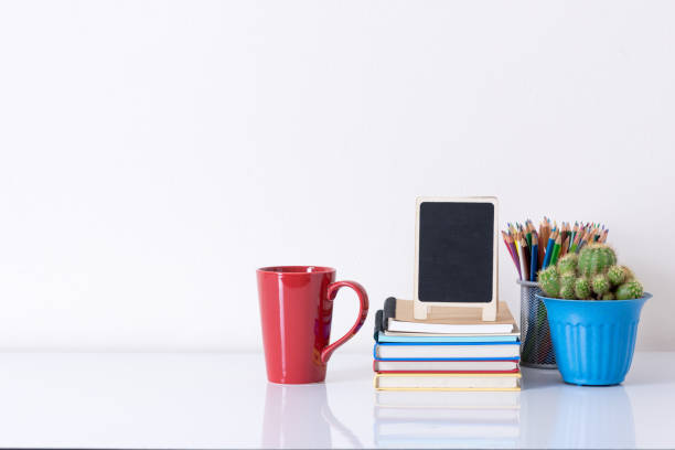 istock Coffee Cup And Books On Table Against White Background 1142370944