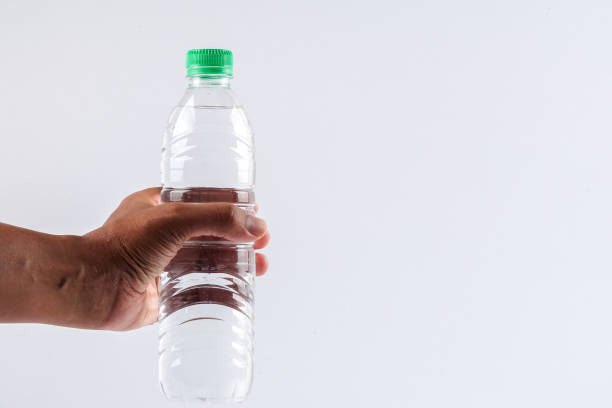 istock Cropped Hand Holding Water Bottle Against White Background 1142371085