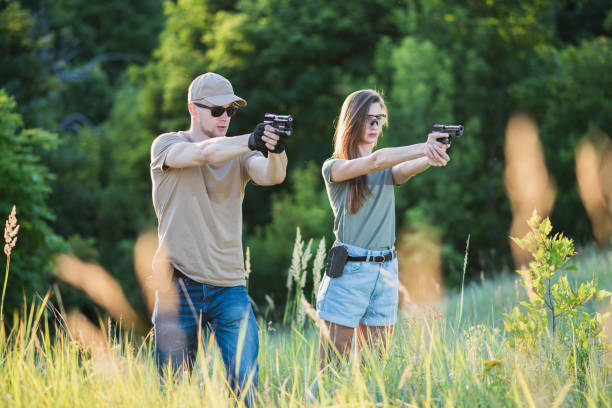 インストラクターは、その範囲でピストルを撃つことを女の子に教える - gun women handgun armed forces ストックフォトと画像