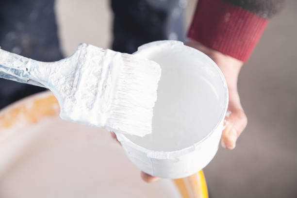istock Man hands paintbrush with white paint. Renovation 1142374423