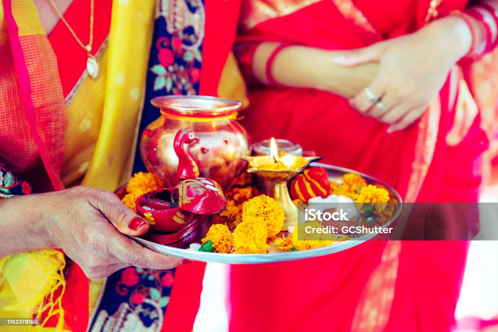 Senior Woman Holding Hindu Prayer Items on a Tray Hindu, Women, Faith, Devotion, Festival - Women Holding a Tray Containing Prayer Articles for Hindu Prayers at a Temple Navratri Stock Photo