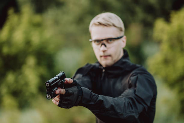 istock instructor with gun in forest leads aiming and posing on camera 1142381562