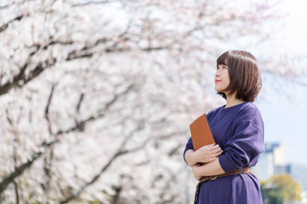 istock Cherry blossoms and women 1142381597
