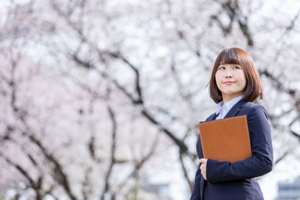 istock Woman in suit and cherry blossom 1142381768