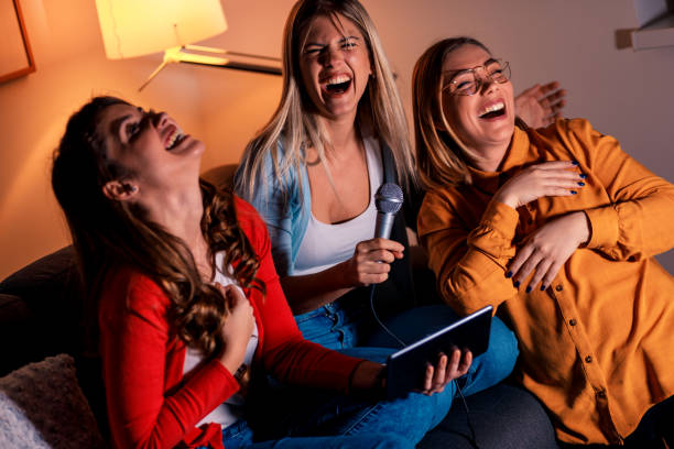 istock Three female friends having fun playing karaoke at home. 1142384790