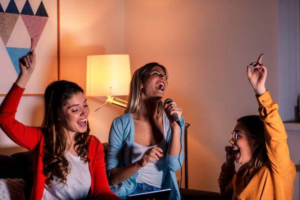 istock Three female friends having fun playing karaoke at home. 1142384794
