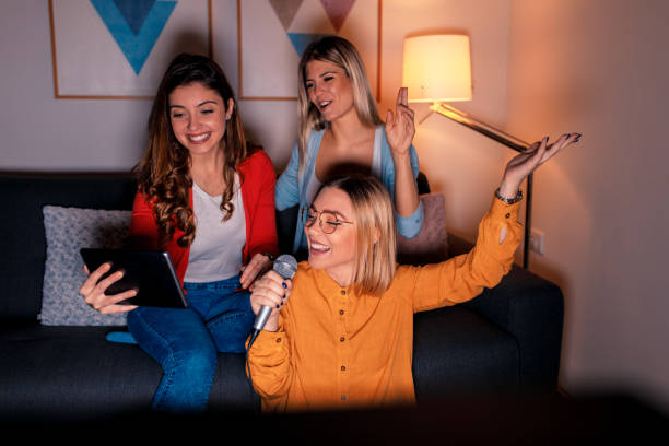 istock Three female friends having fun playing karaoke at home. 1142384941